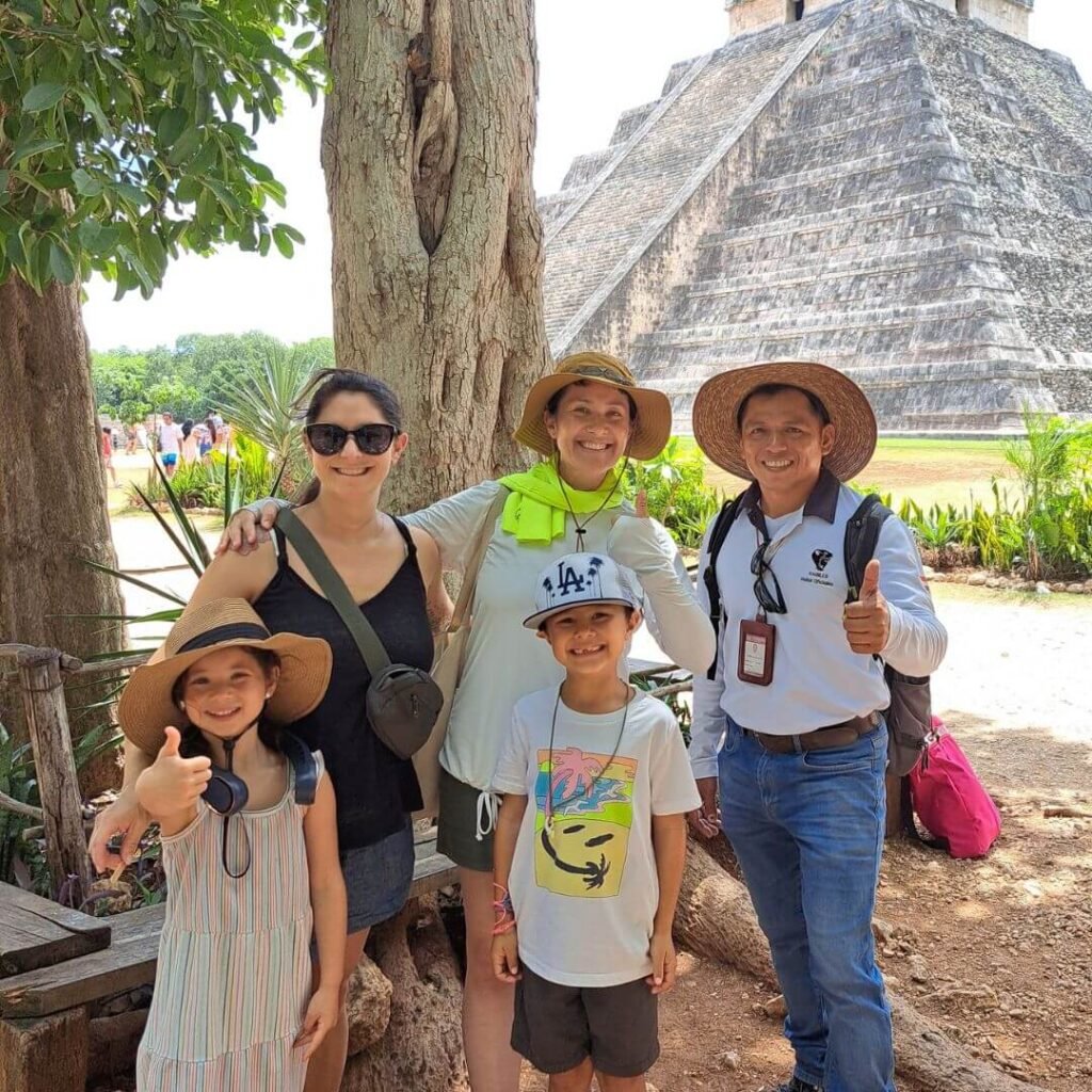 Familia con su guía de Lakin Tours frente al Templo de Kukulkán en Chichén Itzá
